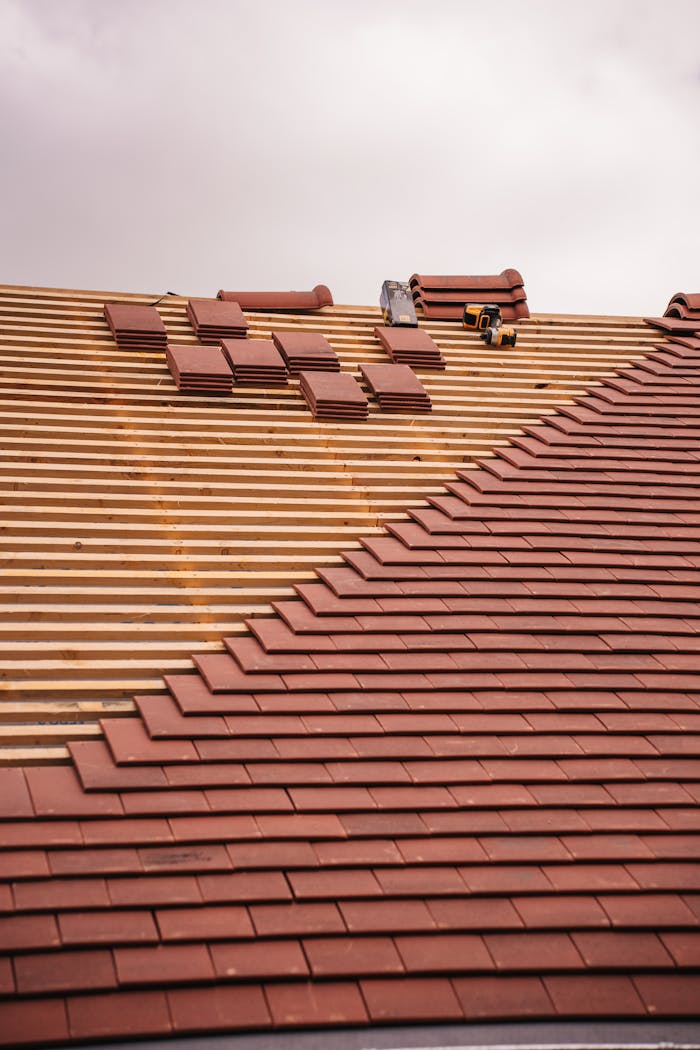 creative-03 Partial installation of a terracotta tile roof on a building in progress.