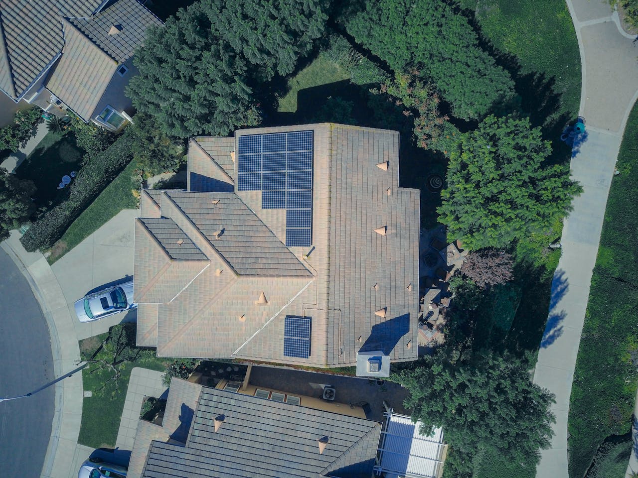creative-02 Top-down aerial view of a house with solar panels, showcasing modern renewable energy solutions.